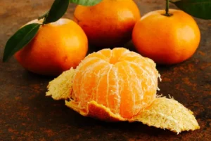 Une mandarine pelée sur une table de nuit, illustrant le concept de manger une mandarine le soir.